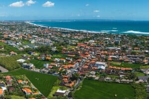 Vista panorámica de la playa de Canggu al atardecer con surfistas y arena dorada